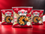 Tr&ecirc;s embalagens vermelhas de gyoza de carne Ajinomoto, com guiozas ilustradas na frente.