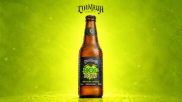 Garrafa da cerveja Louvada Hop Low sobre fundo verde-limão, com rótulo que destaca baixa caloria e ausência de glúten.