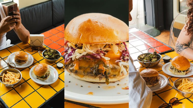 Montagem com hambúrguer recheado de carne, queijo e vegetais, mesas com sanduíches, batatas fritas e clientes no restaurante.
