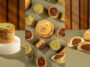 Montagem de doces do Kebab Shop com massas finas recheadas de cremes verde e marrom e biscoitos redondos com recheio escuro.