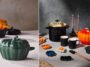Montagem de panelas Le Creuset em formato de ab&oacute;bora nas cores verde e laranja, ao lado de pe&ccedil;as pretas com morcegos e velas acesas.