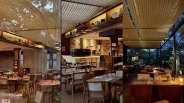 Salão do Maremonti Vila Olímpia com mesas postas, teto de madeira e forno de pizza ao fundo.