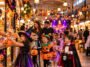 Crian&ccedil;as fantasiadas de bruxa, esqueleto, ab&oacute;bora, fada e vampiro recebem doces em mercado decorado para Halloween.