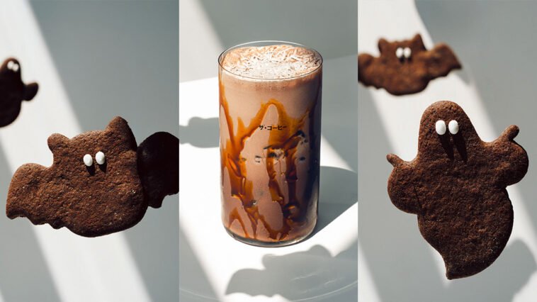 Montagem com biscoitos escuros em formato de morcego e fantasma e bebida gelada cremosa com calda nas paredes do copo.